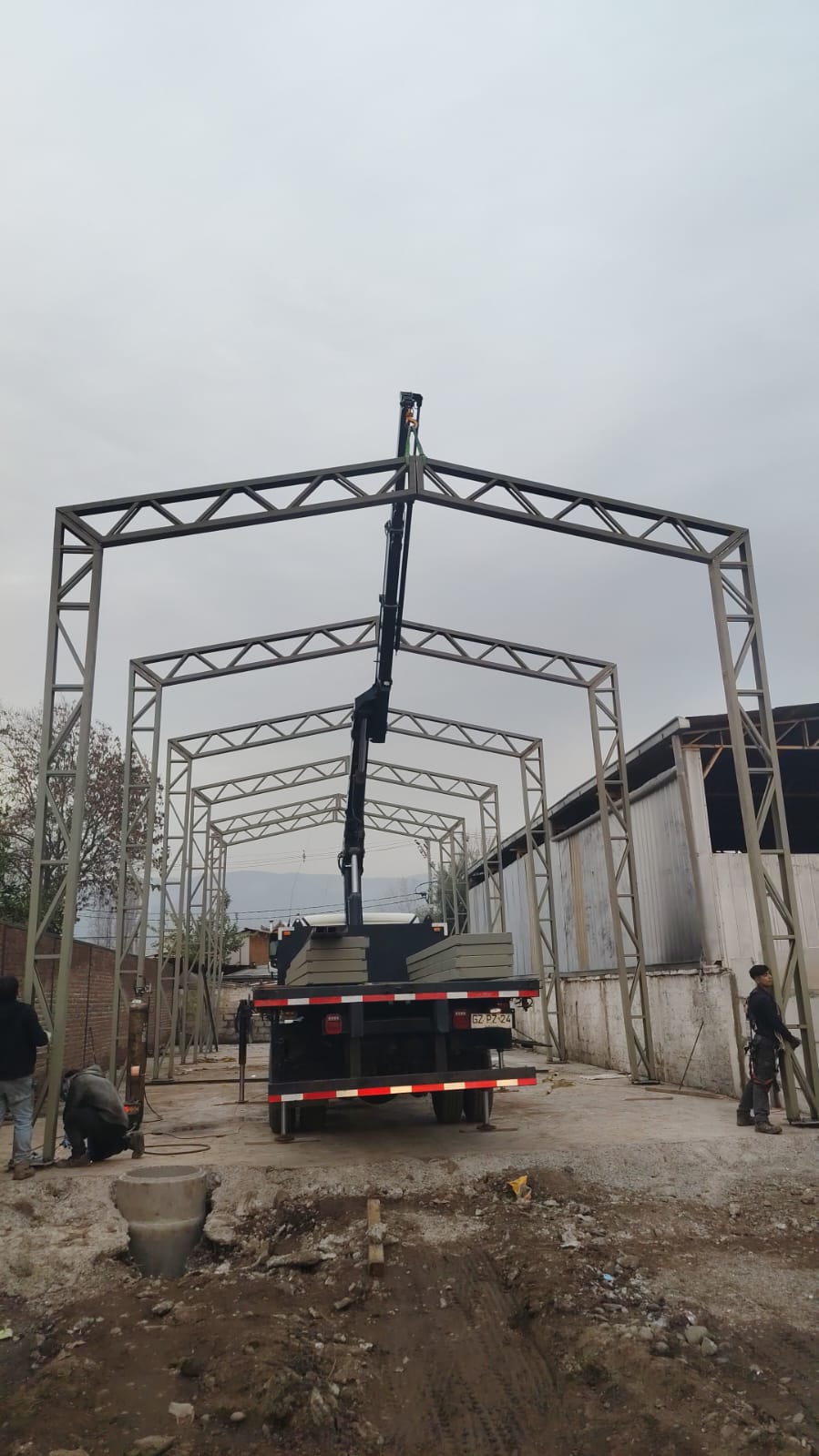 Izaje de estructura metálica en obra con camión pluma